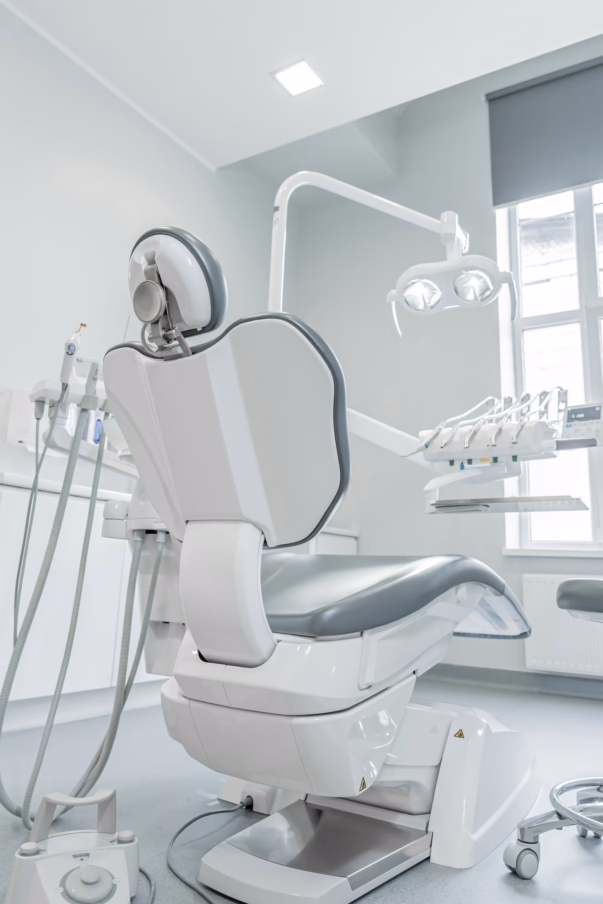 A dental treatment room with daylight coming through a window.